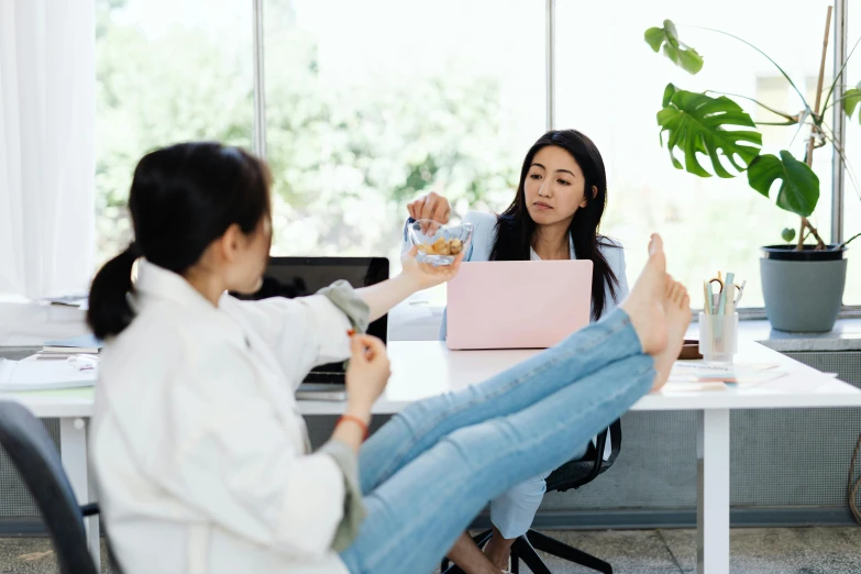 the two woman are sitting at the table