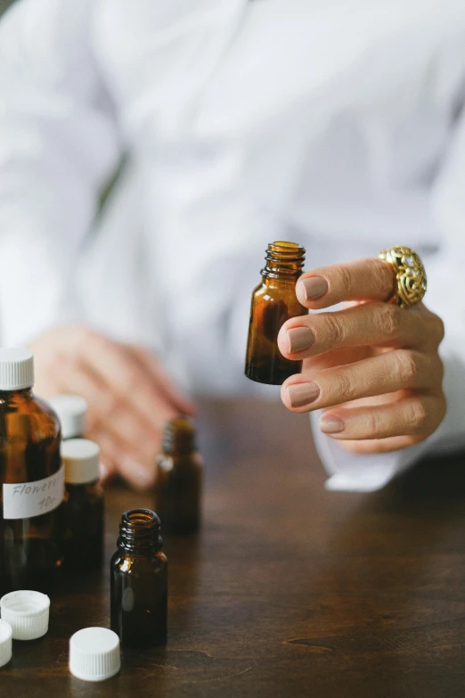 woman in white shirt holding a bottle next to pills