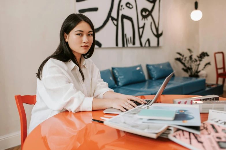 a woman sitting at a desk working on a laptop