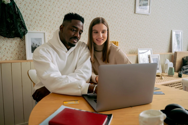 a man and woman on a laptop sitting at a table