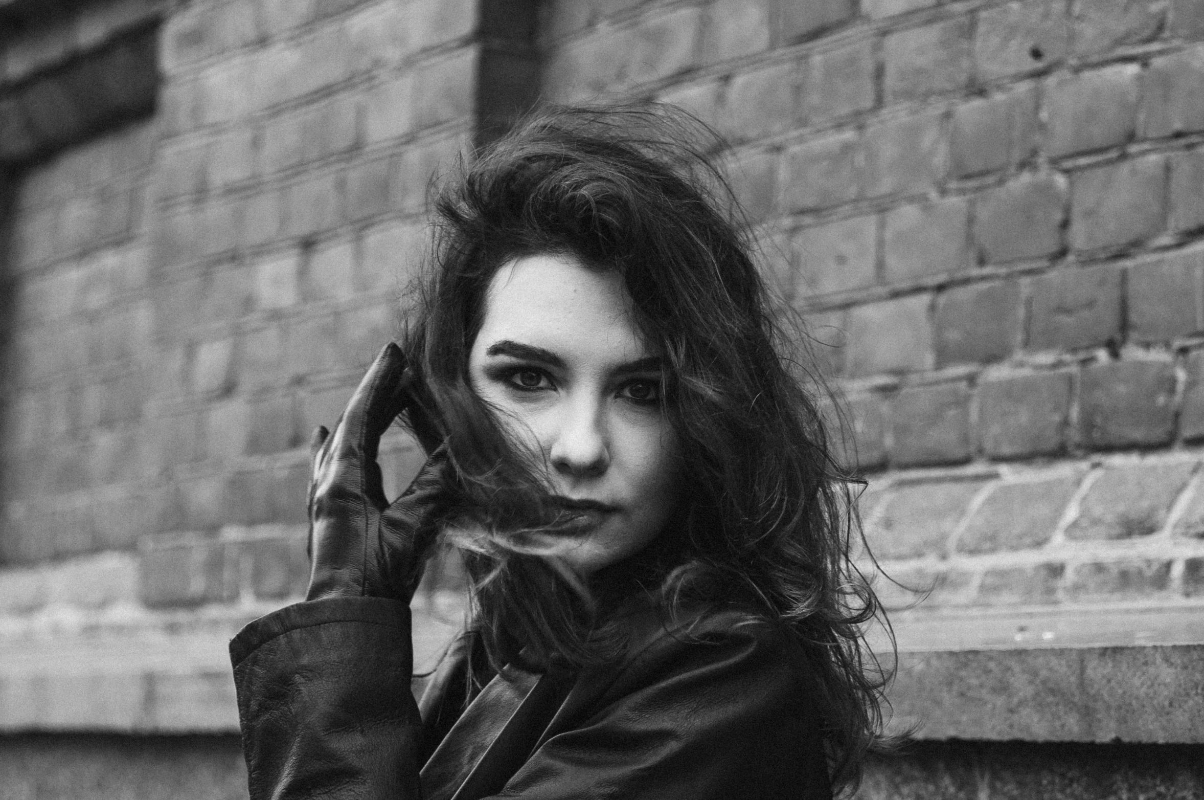 an attractive woman in black holding a cigarette