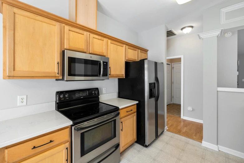 a kitchen with a black stove top oven and light wood cabinets