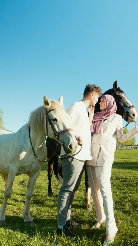 a man in white walking a horse down a field