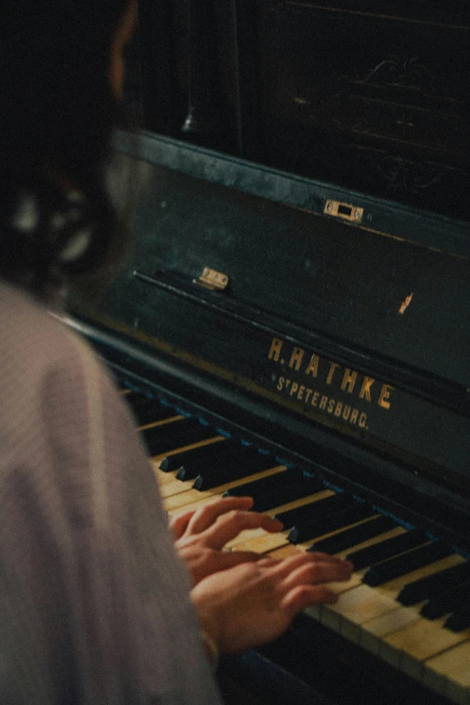 a person sitting at a piano playing music