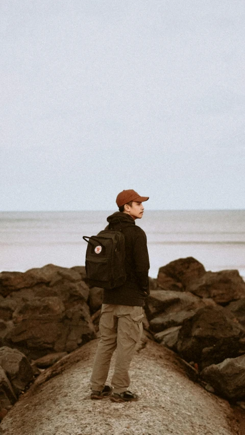 a person standing on a rock by the water