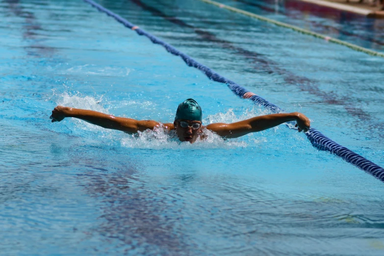 woman swimming in a pool wearing a blue hat