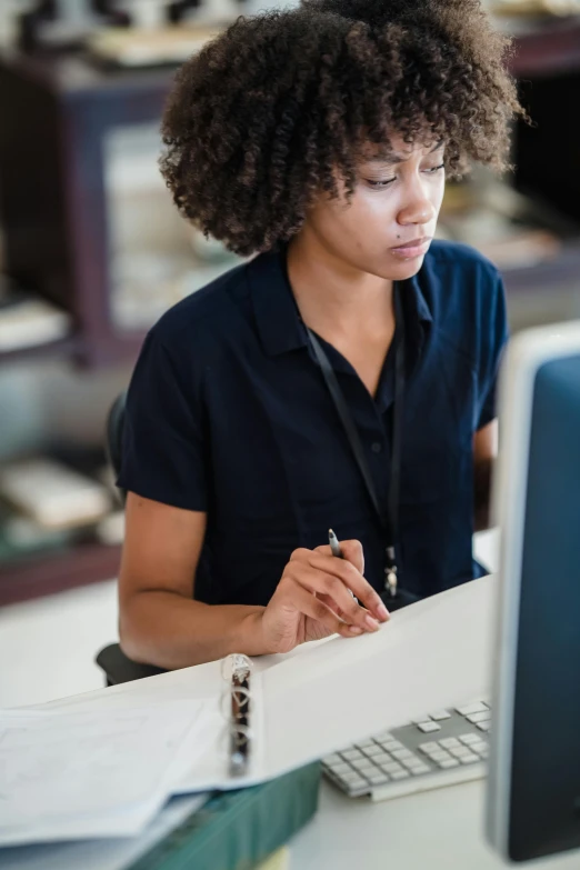 a woman sits in front of her computer writing