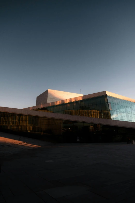 a large glass building with the sky in the background