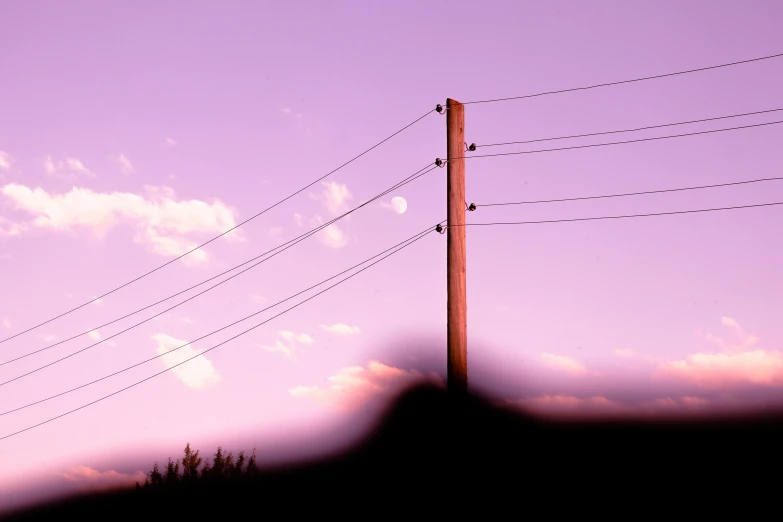 a tall red pole with lots of telephone wires hanging over it