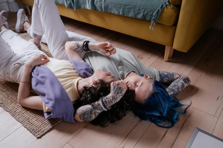 two people laying on the ground while one woman is covering her eyes