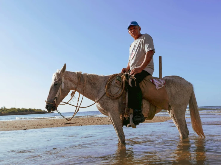 a man in cowboy hat and glasses sitting on top of a horse