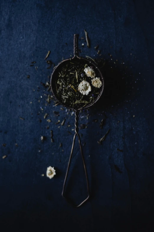 dried flowers sit on the table next to a small metal container