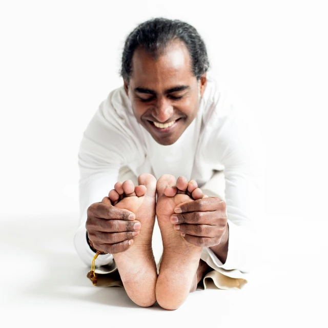 a man is sitting and posing for a picture with his bare feet