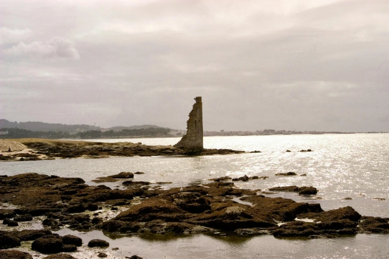 a view of the ocean and an old lighthouse on land