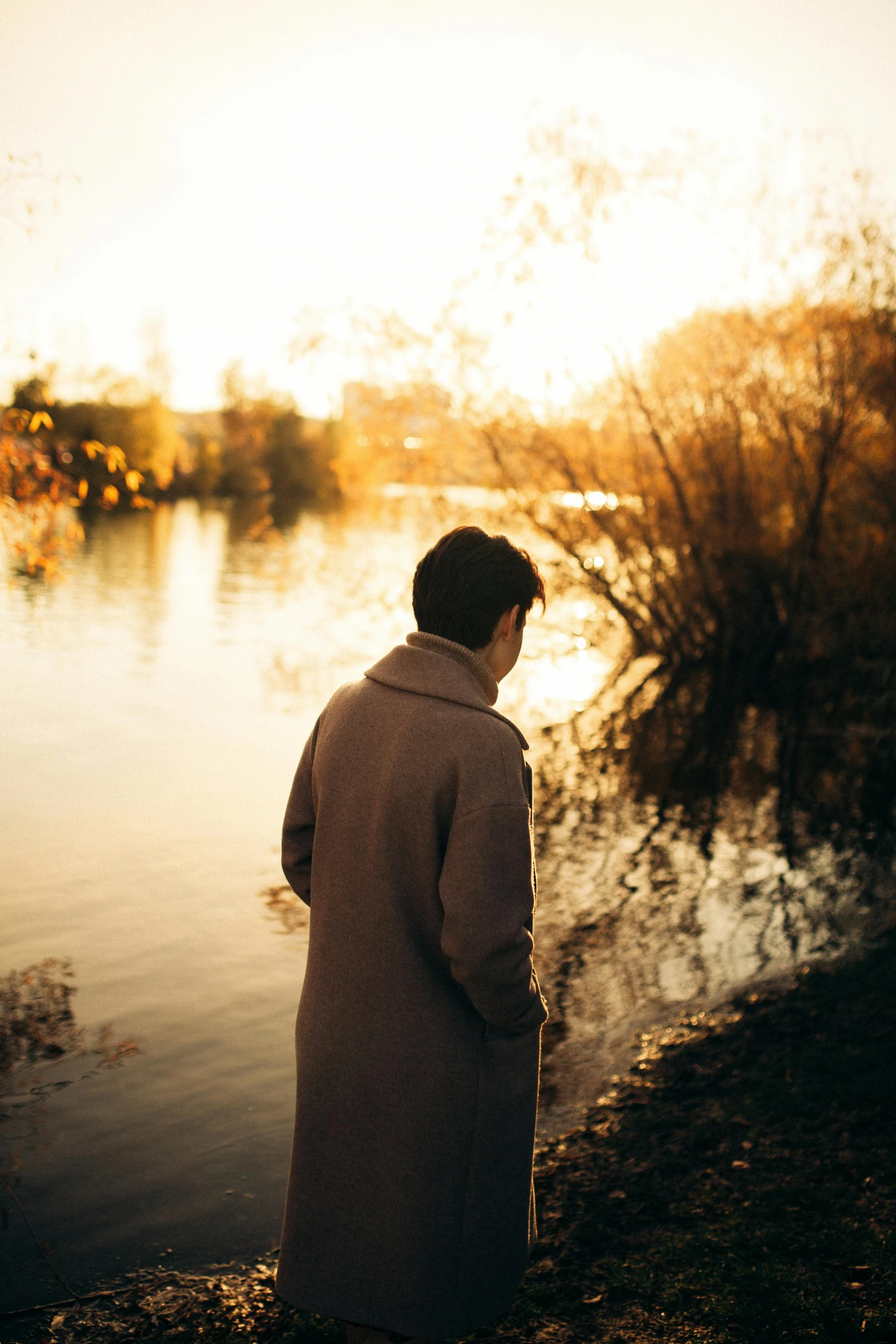 a man is standing by the water on a sunny day