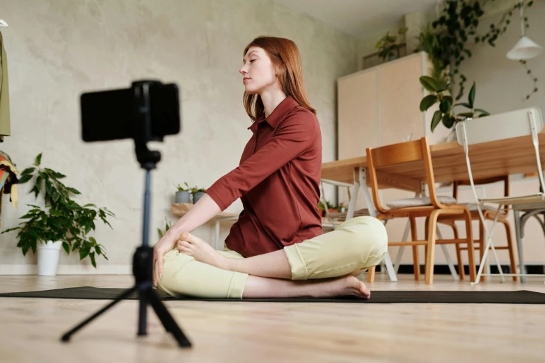 a woman meditates on the floor in a room