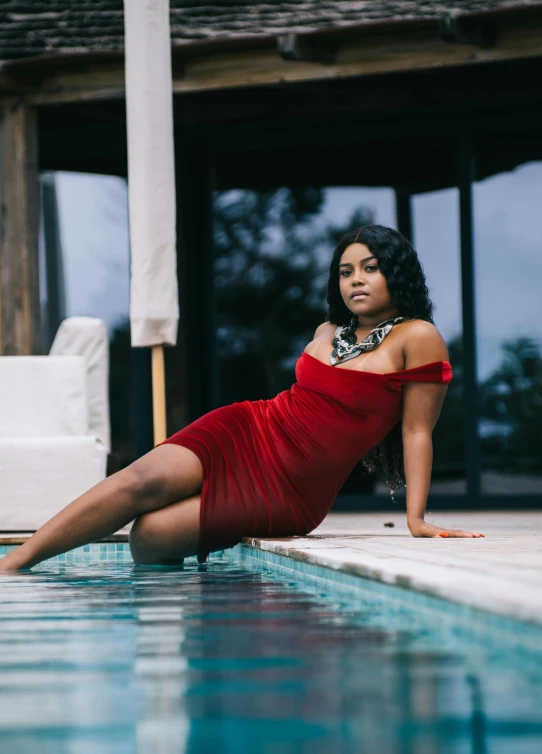 a woman sitting on the edge of a pool