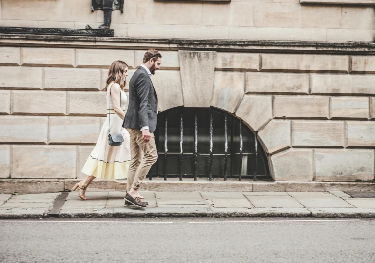 a man and woman walking down a sidewalk