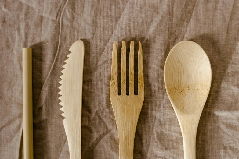 some wooden spoons and forks laying next to each other