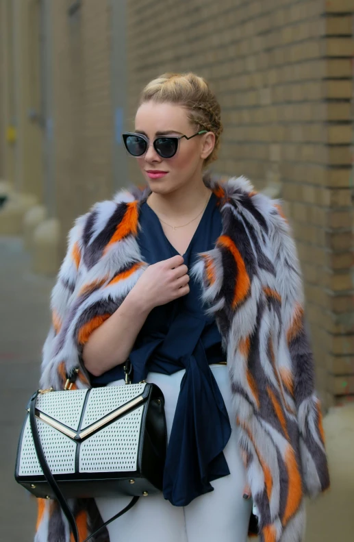 a woman in white pants and a fur jacket