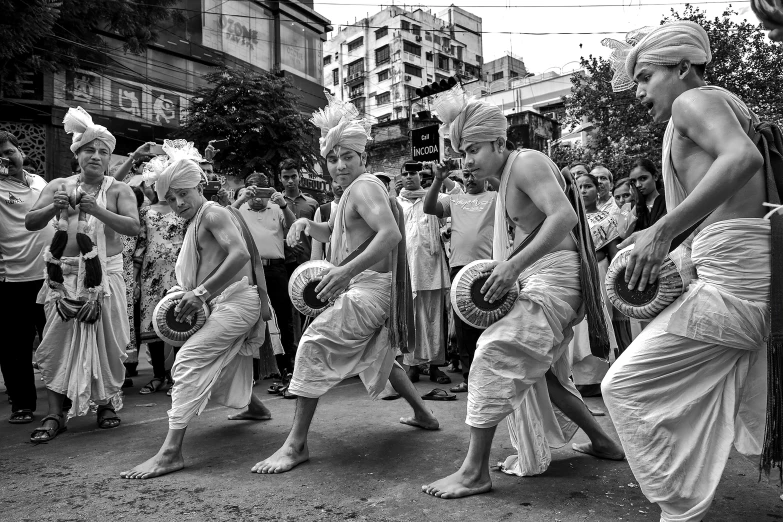 men walking down the street with one wearing a headdress