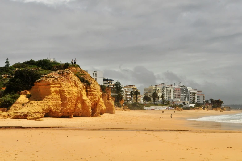 people walk along the beach and on the sand