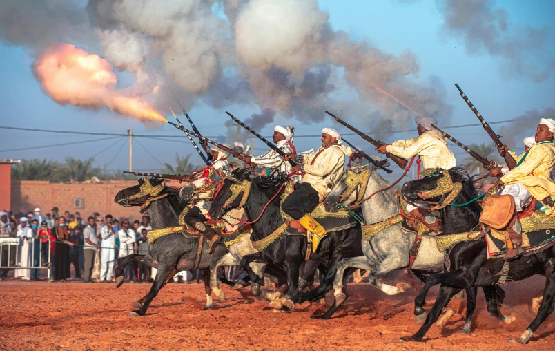 several men riding horses and holding spears during a battle