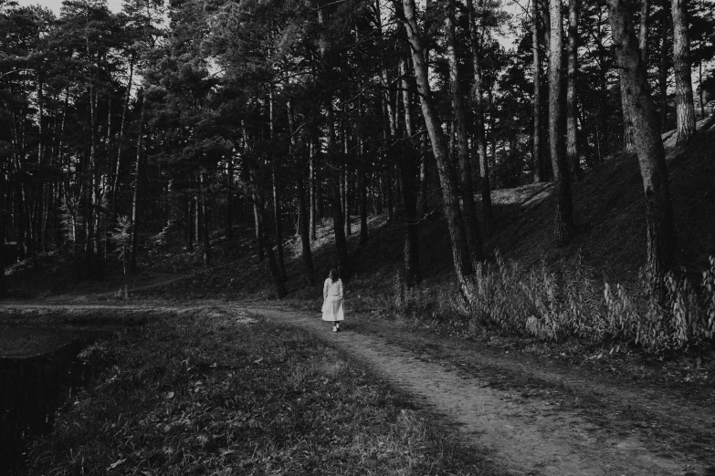 a woman stands alone in a clearing surrounded by trees