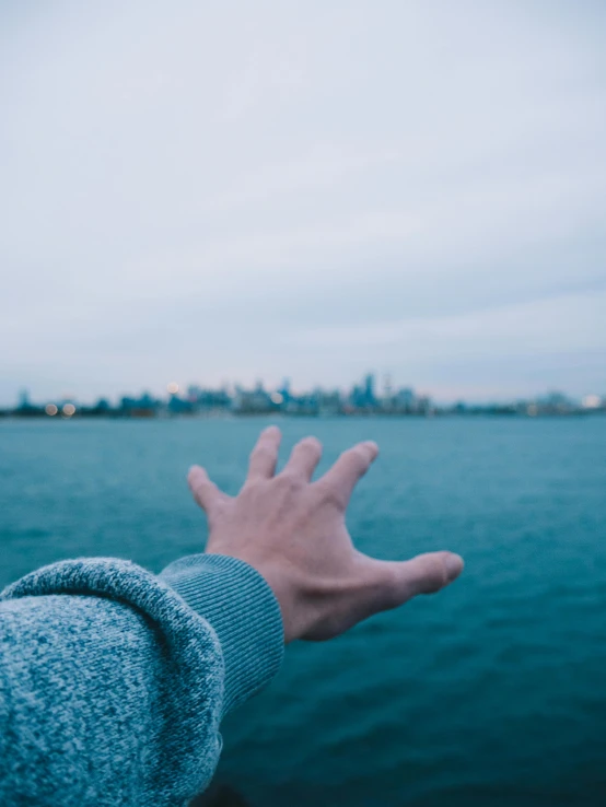 a person is holding his hand out on the water