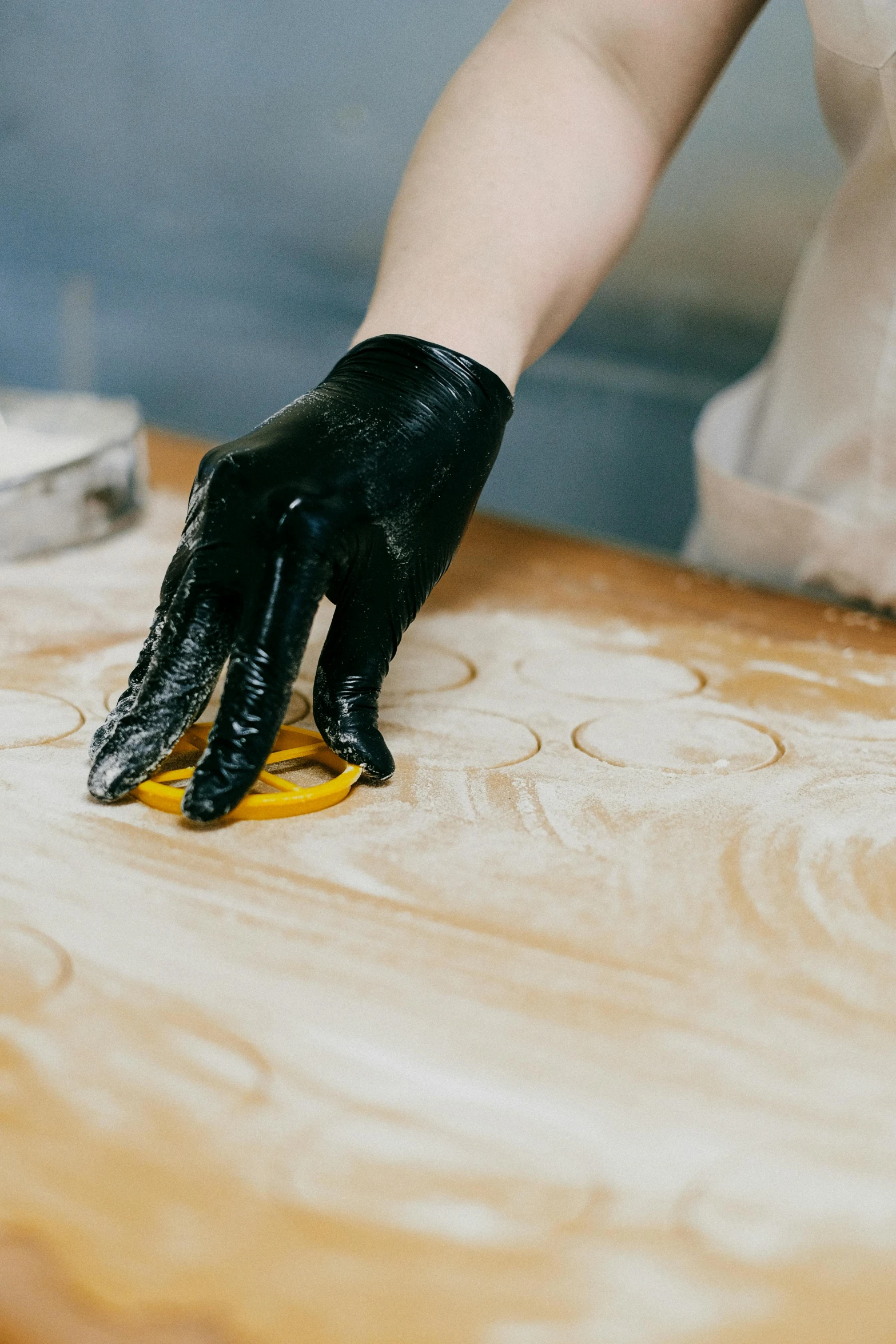 a person wearing rubber gloves, black gloves on a wooden table