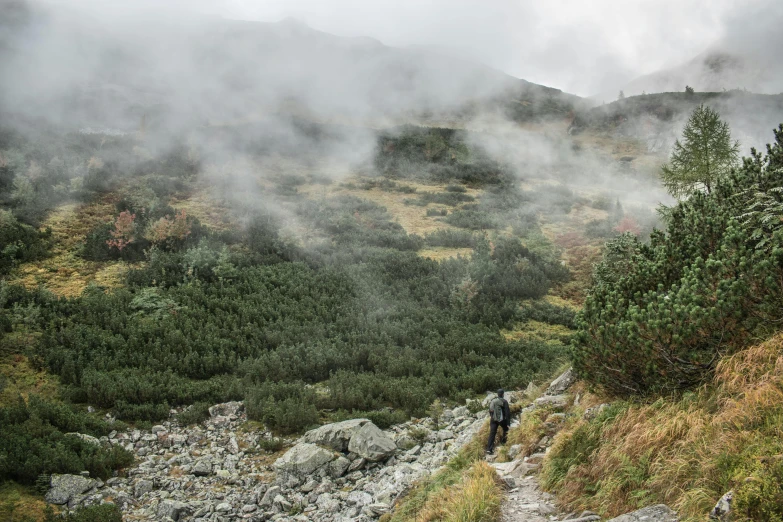 there is a man walking on the mountain trail