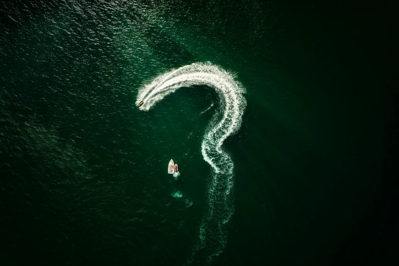 two boats are coming toward the light on a dark water surface