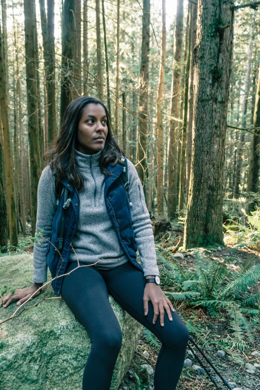 a woman in the forest holding an odd rope