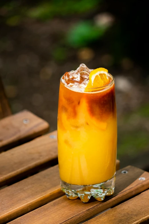 a glass filled with soing sitting on top of a table