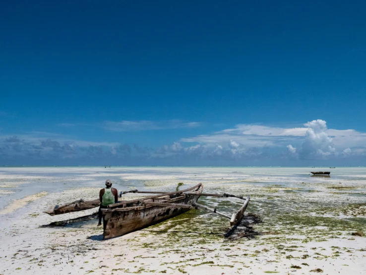 a small wooden boat on a sandy beach