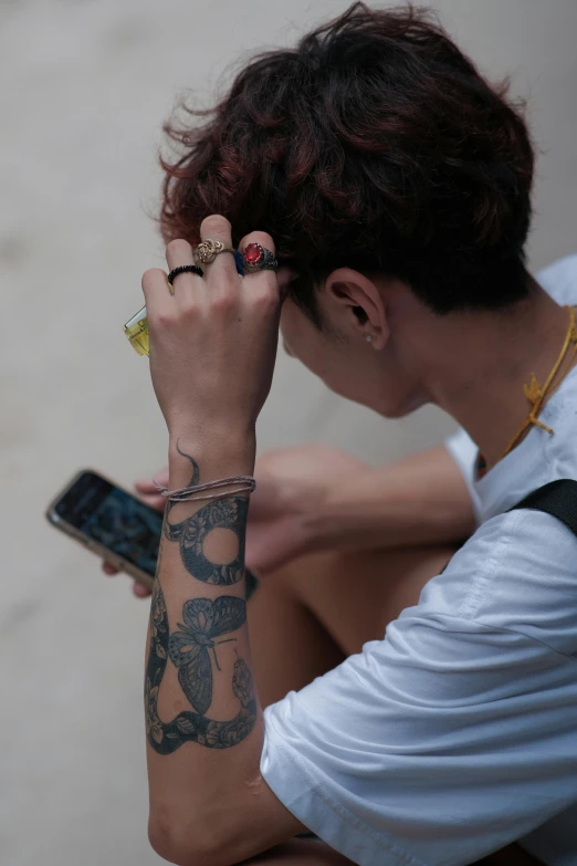 a person sitting on the ground holding a cell phone