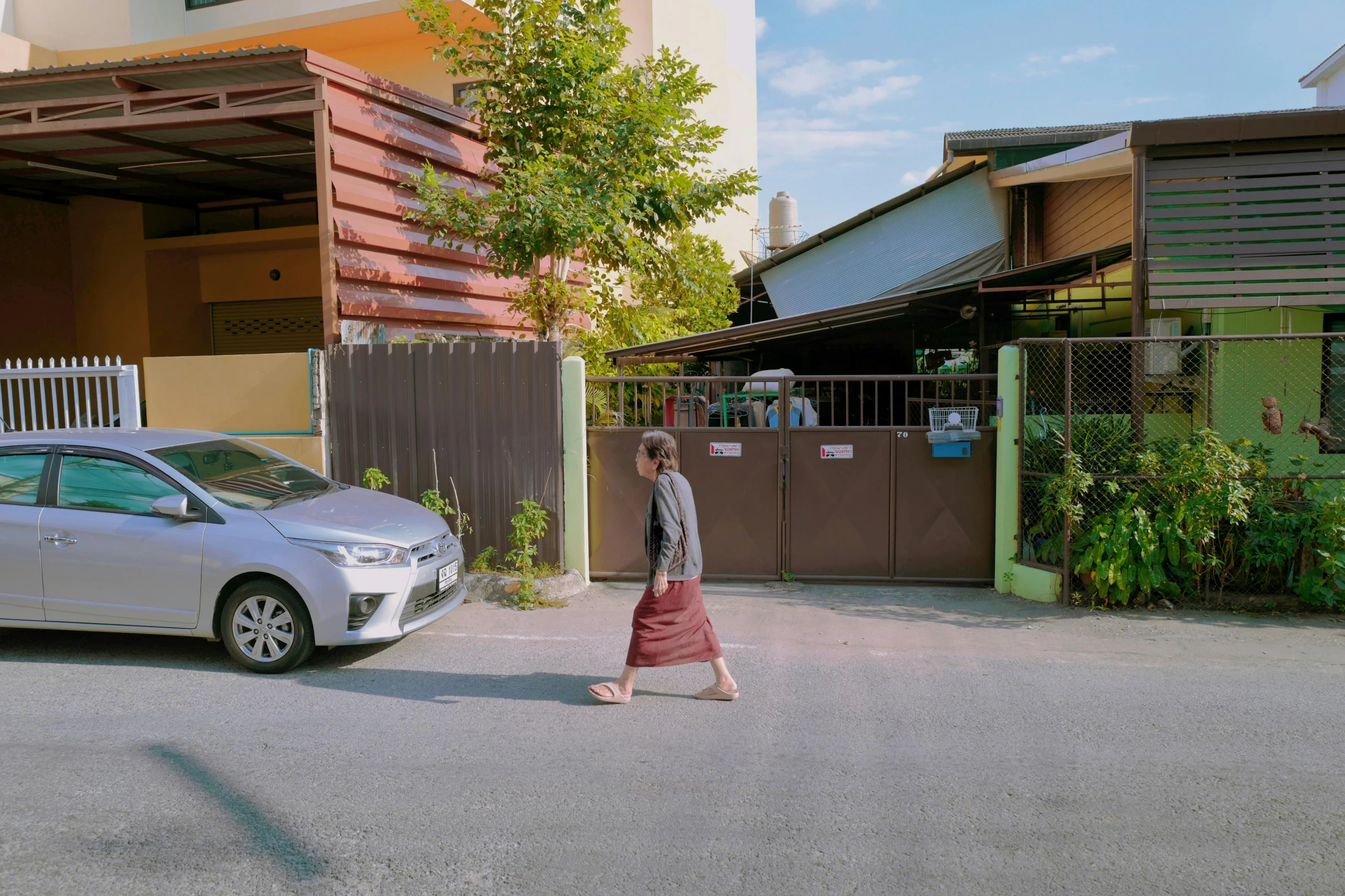 a woman walking down the street in front of a house