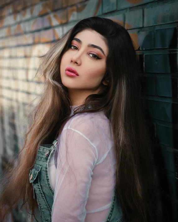 woman posing with long, straight hair near wall