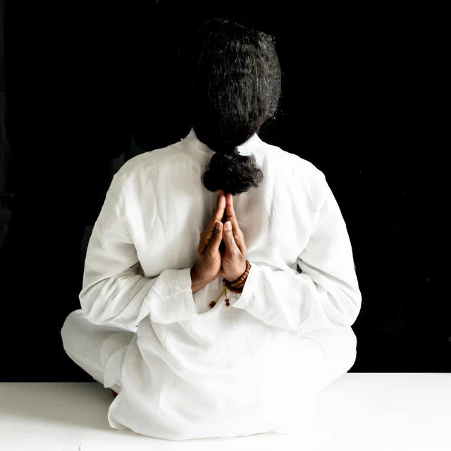 a woman wearing white doing yoga poses while sitting down