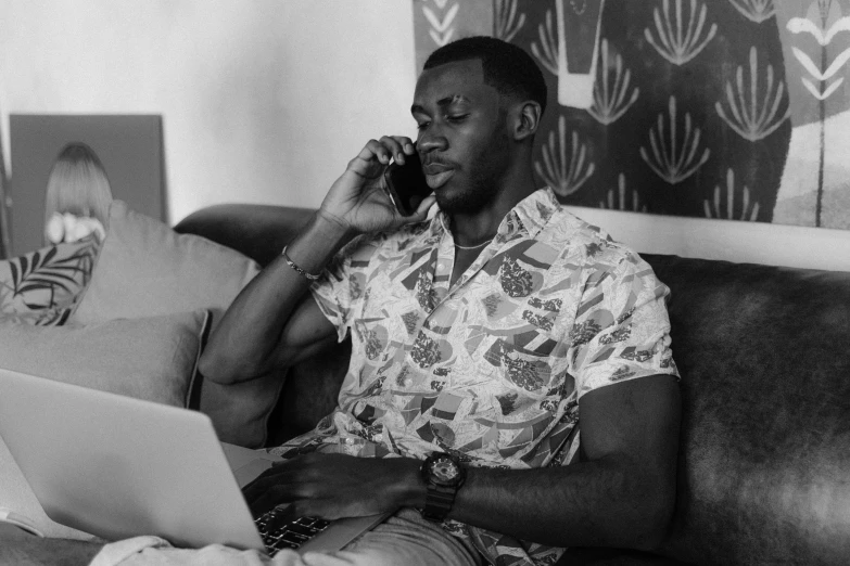 a man sitting on a couch while on the phone