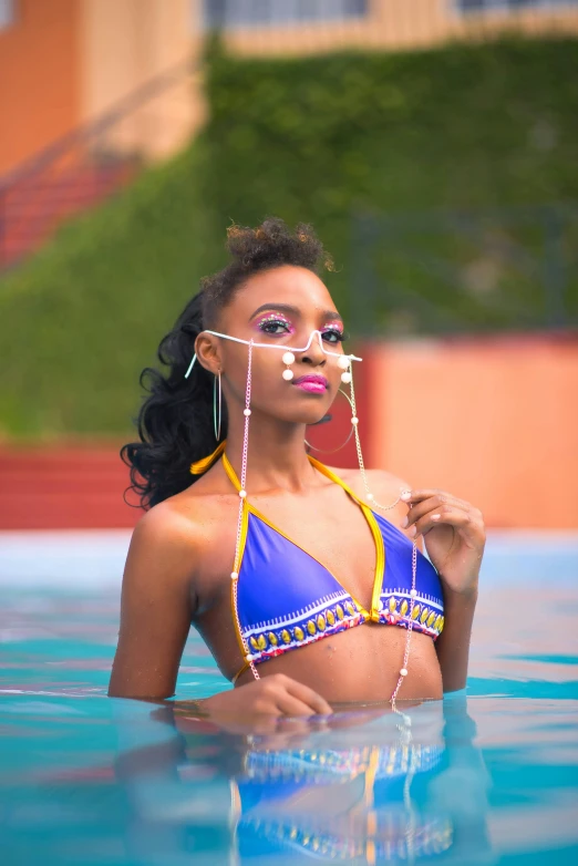 a pretty woman wearing a blue bikini standing in the water