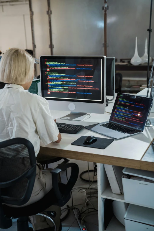 woman sitting at a desk using a laptop computer