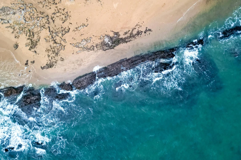 an aerial view of water and sand near the beach