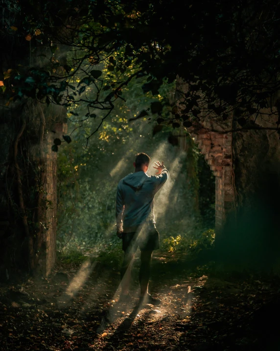 a boy is standing alone in the forest