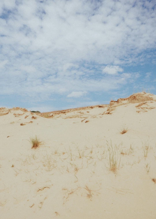 the man is walking on the sand hill