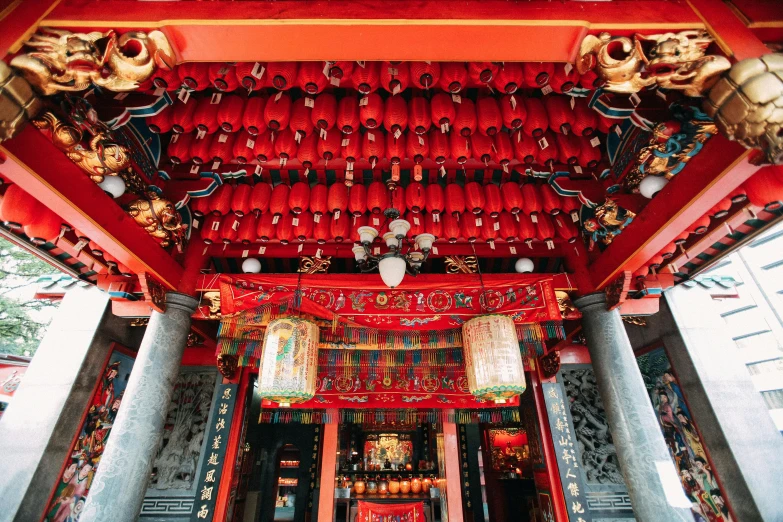 the front door of an oriental structure in red and orange