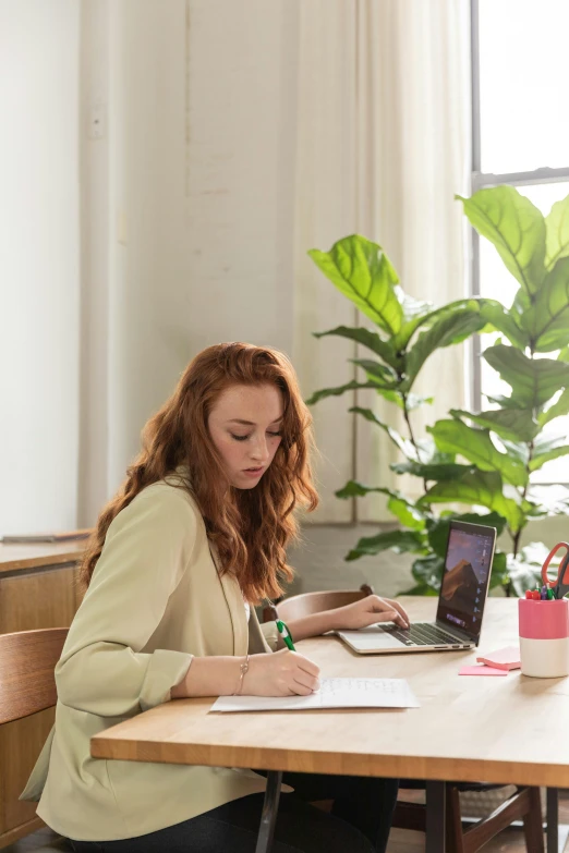 a woman sitting at a table with a laptop