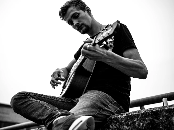 black and white po of a man playing the guitar