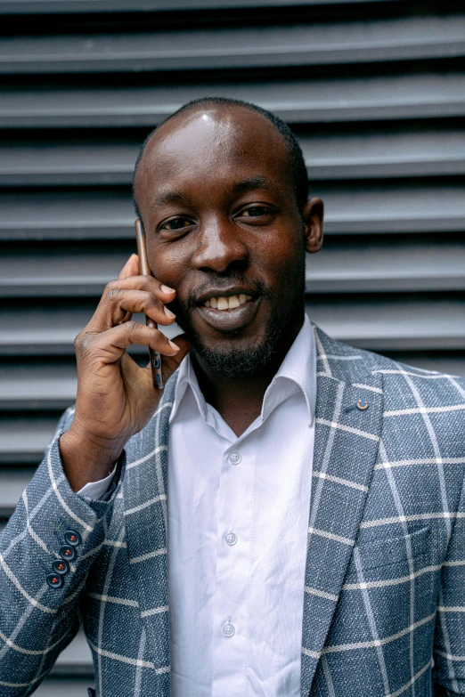 a smiling man is talking on the phone