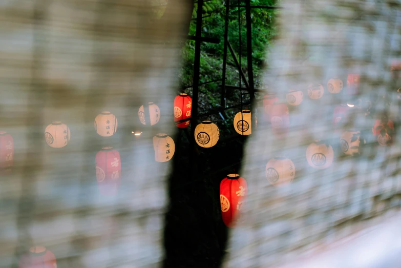 lights shine behind a curtain that includes small red lanterns